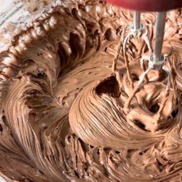 Icing being mixed together with a hand held mixter. 