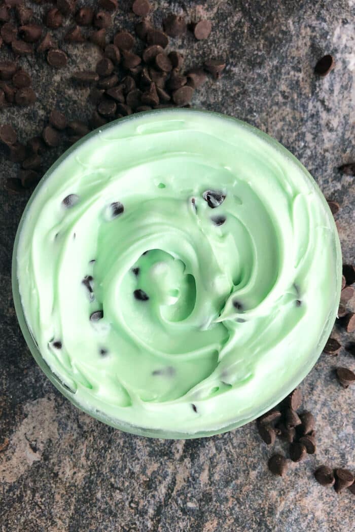 Mint Icing With Chocolate Chips in glass bowl on rustic gray background. 