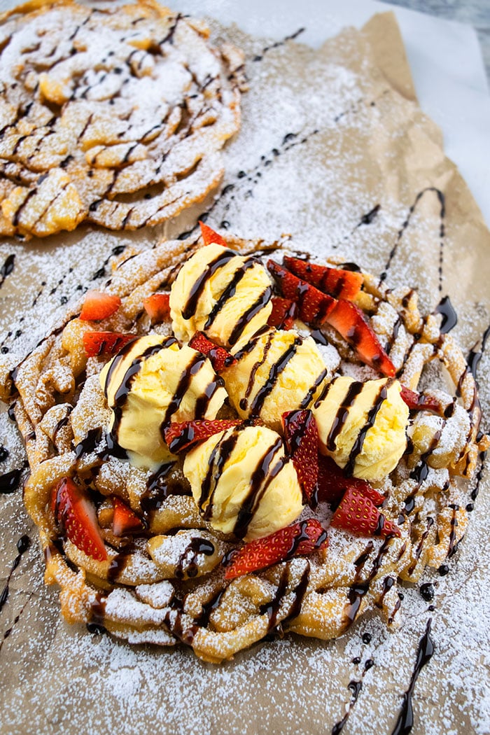Easy Funnel Cake Topped with Ice cream, Strawberries and Chocolate Syrup