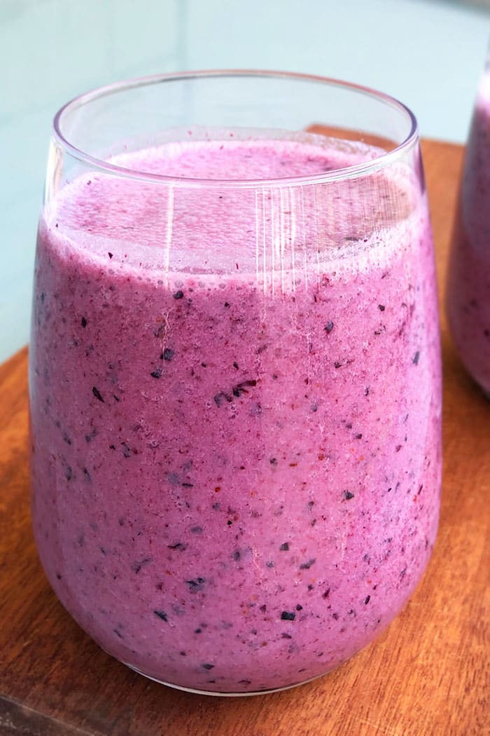 Homemade Blueberry Smoothie in a Clear Cup Placed on a Wood Base