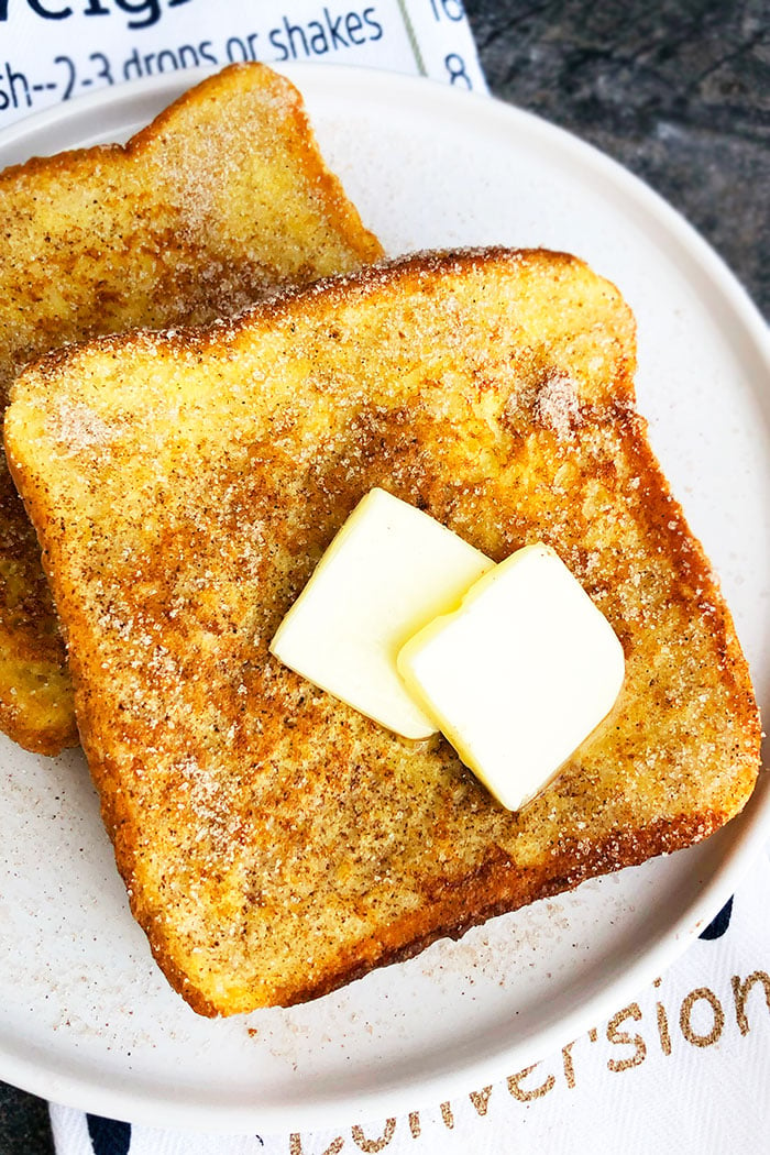 Easy Cinnamon French Toast on White Plate Topped with Sliced Butter