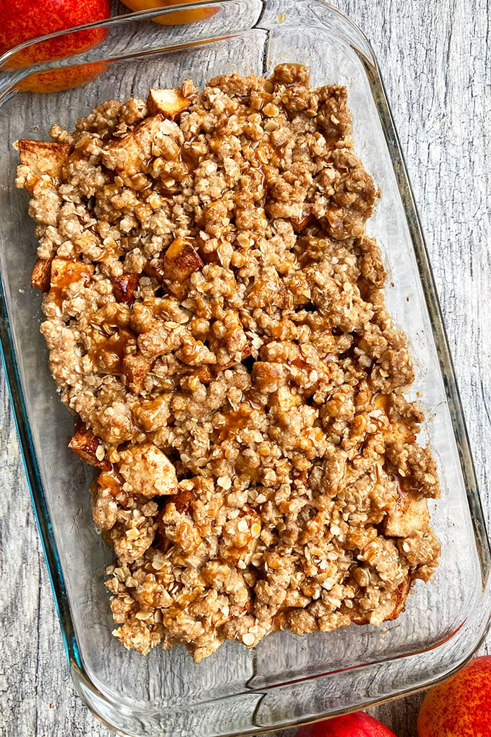 Overhead Shot of Easy Apple Crisp With Crispy Oat Topping in Glass Dish on Rustic Gray Background