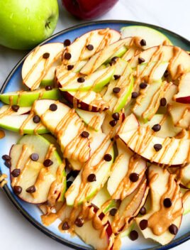 Easy Homemade Apple Nachos with Peanut Butter, Almond butter and Chocolate Chips in Blue Plate