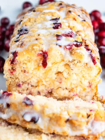 Easy Homemade Orange Cranberry Bread with Glaze on White Surface