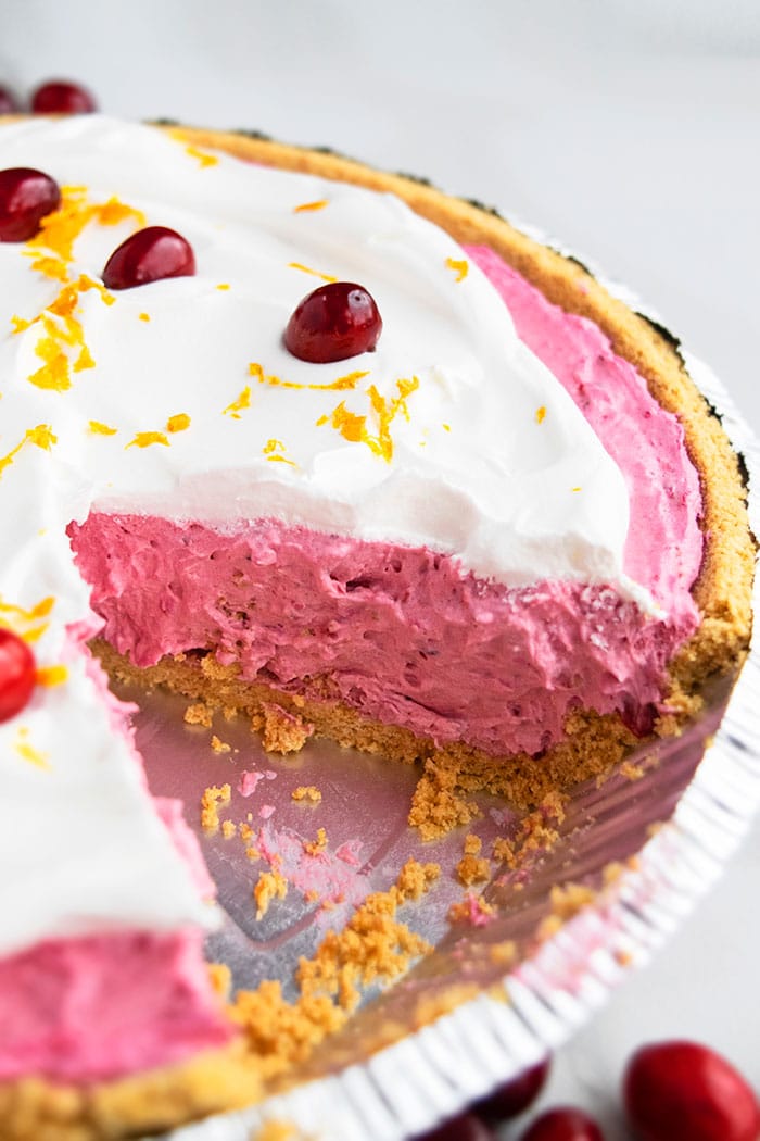 Closeup Shot of Easy Cranberry Pie in Graham Cracker Crust and Whipped Cream Topping on a White Background