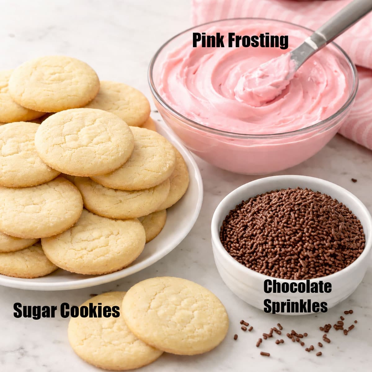 Ingredients for making decorated floral cookies on white marble background.