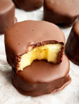 Stack of Frozen Chocolate Covered Bananas Bites on White Parchment Paper