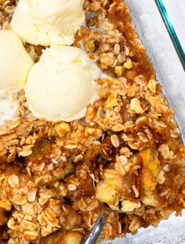 Easy Homemade Banana Crumble in Glass Dish with Scoops of Vanilla Ice Cream