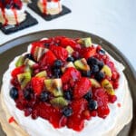 Easy Homemade Pavlova Topped With Jam and Fresh Fruits on Metal Dish.