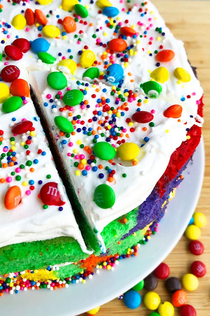 Overhead Shot of Sliced Layer Cake with Whipped Cream, Sprinkles, Candies