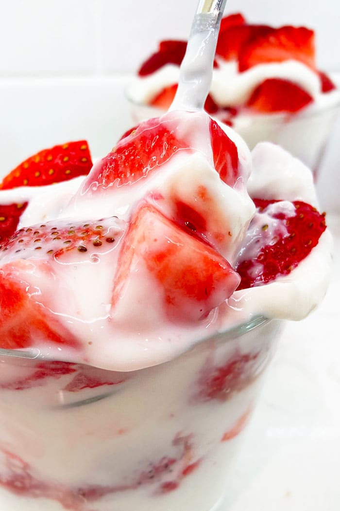Spoonful of Fresh Strawberries with Vanilla Cream in Glass Cup