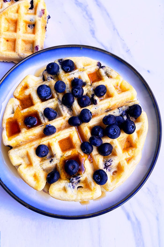Blueberry Belgian Waffles on White Plate with Light Blue Background- Overhead Shot