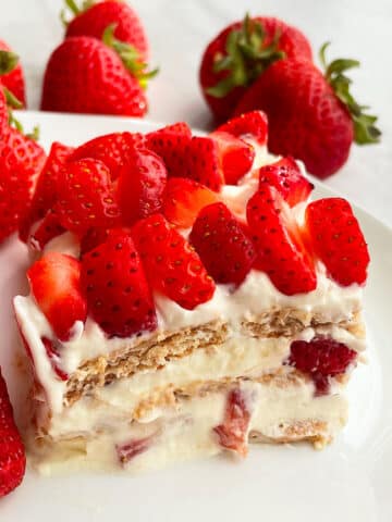 Slice of Old Fashioned No Bake Icebox Cake With Strawberries on White Plate
