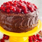 Easy Chocolate Raspberry Cake With Ganache Frosting on Yellow Cake Stand