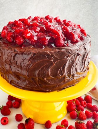 Easy Chocolate Raspberry Cake With Ganache Frosting on Yellow Cake Stand