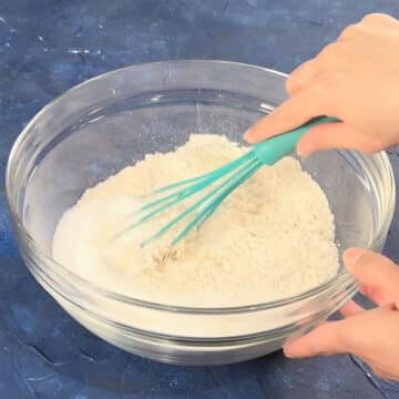 Dry ingredients being whisked together in a glass bowl. 