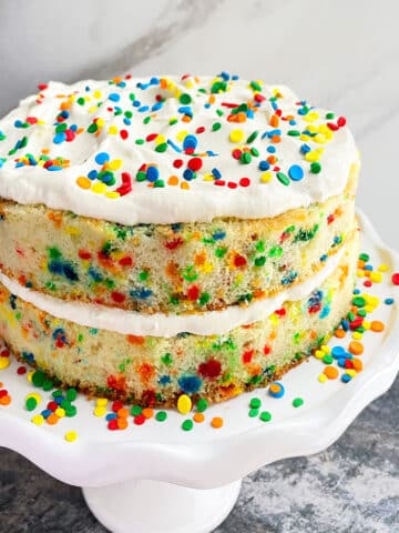 Easy Homemade Funfetti Cake From Scratch on White Cake Stand With Marble Background