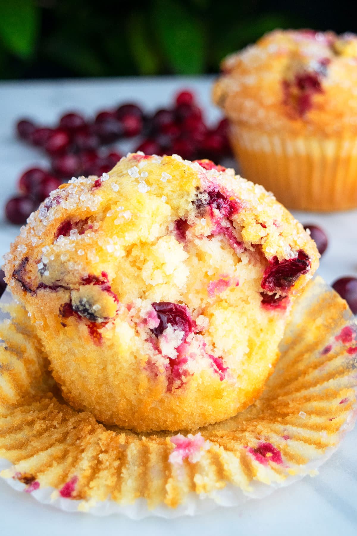 Partially eaten muffin with liner partially removed. 