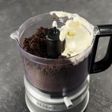 Cream cheese added to Oreo crumbs in food processor. 