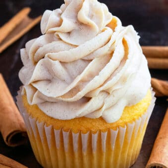 Swirl of Easy Fluffy Brown Sugar Frosting on Top of Vanilla Cupcake With Rustic Black Background