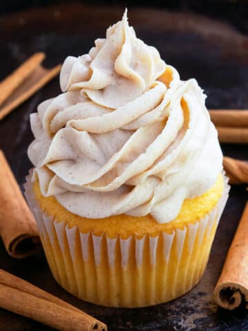 Swirl of Easy Fluffy Brown Sugar Frosting on Top of Vanilla Cupcake With Rustic Black Background