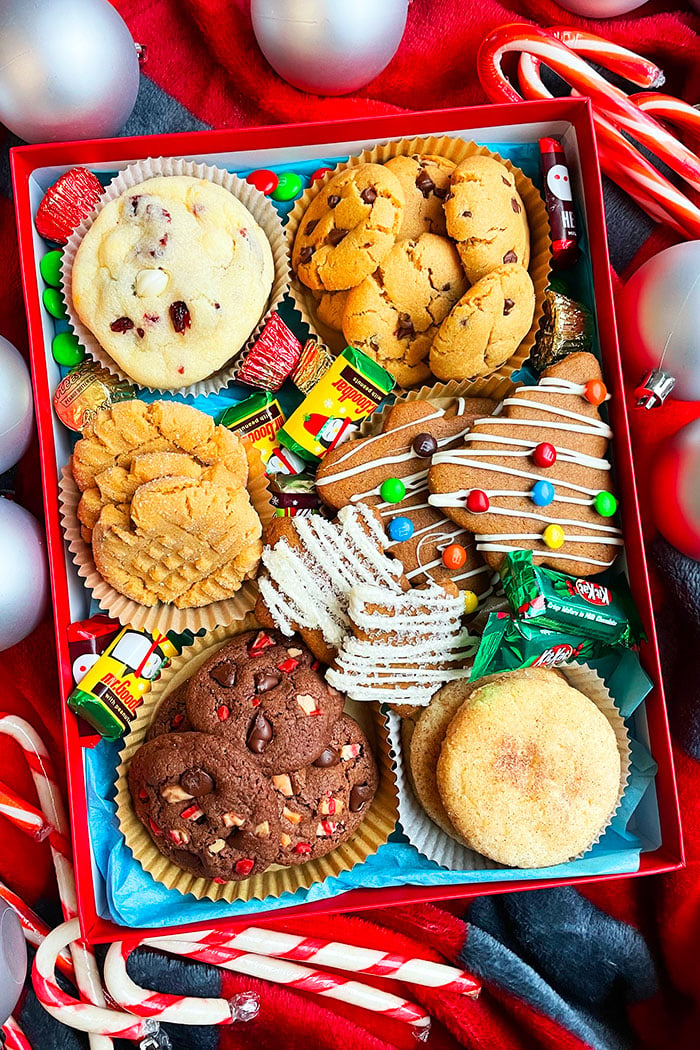 Best Holiday Cookie Boxes on a Red Holiday Background With Ornaments and Candy Canes