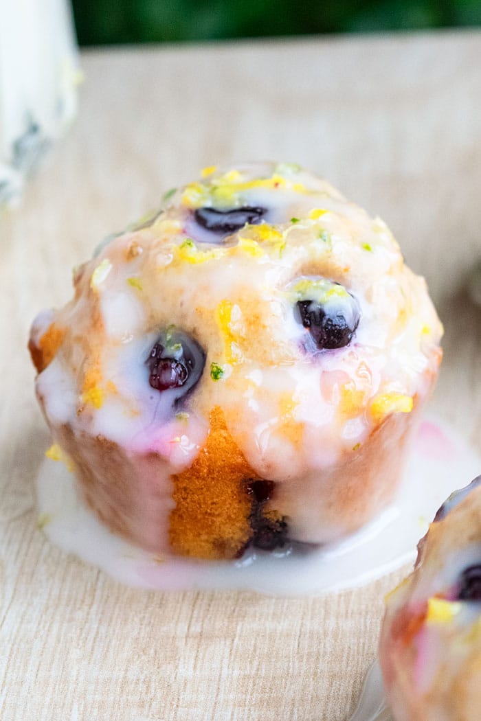 Blueberry Muffin With Poured Lemon Icing on Rustic Wood Background