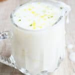 Easy Lemon Glaze or Lemon Drizzle Icing in Glass Cup on Rustic Wood Background