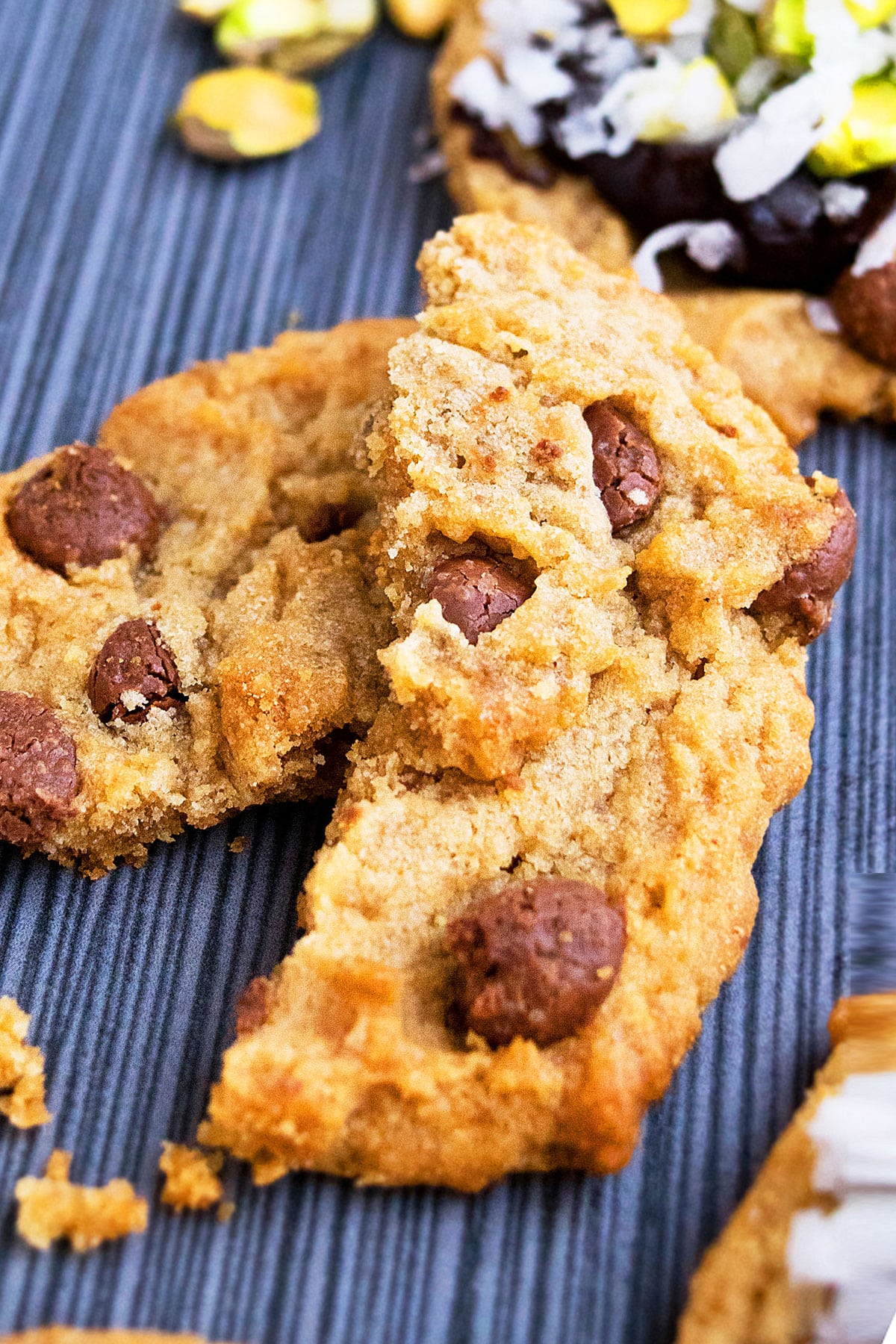 Peanut Butter Chocolate Chip Cookie Broken in Half on Striped Gray Background.
