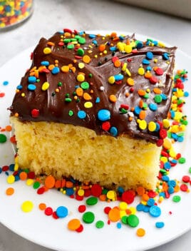 Slice of Yellow Sheet Cake With Chocolate Frosting on White Plate