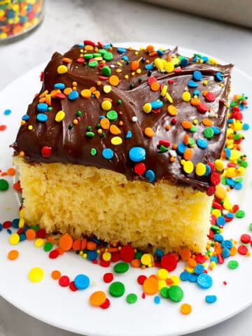 Slice of Yellow Sheet Cake With Chocolate Frosting on White Plate