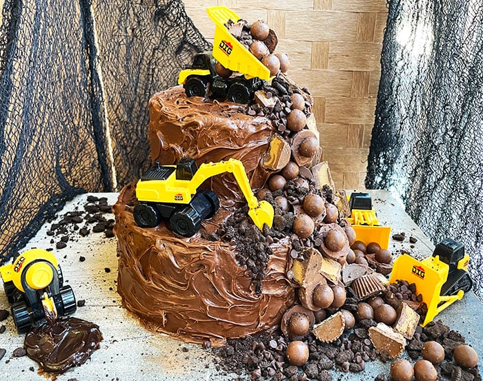 Tiered Bulldozer and Truck Construction Birthday Cake on Rustic Background