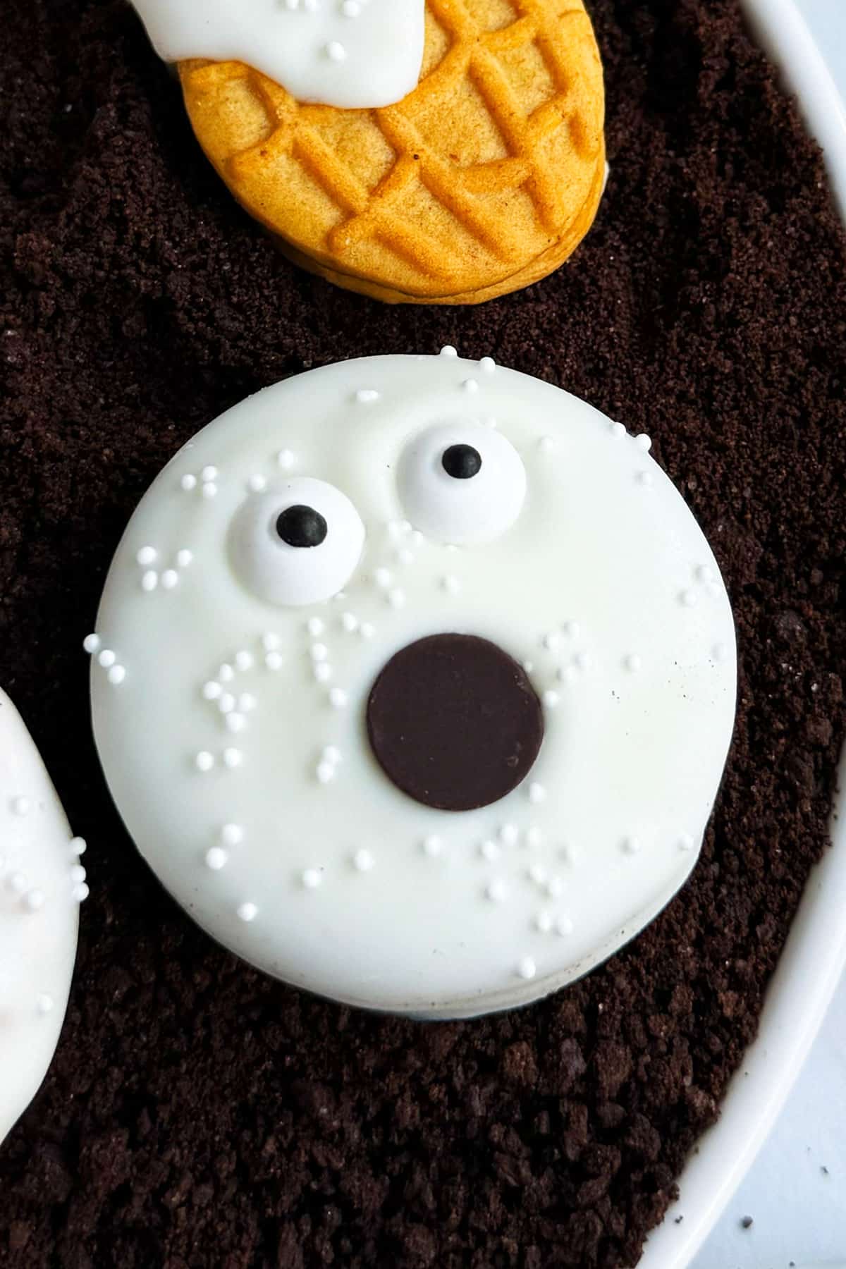 Easy Ghost Oreos in White Dish of Cookie Crumbs- Closeup Shot. 