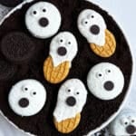 Easy Ghost Cookies With Oreos and Nutter Butter on White Dish With Cookie Crumbs.