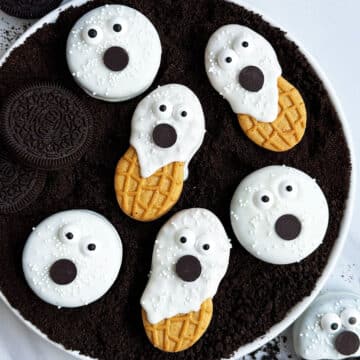 Easy Ghost Cookies With Oreos and Nutter Butter on White Dish With Cookie Crumbs.