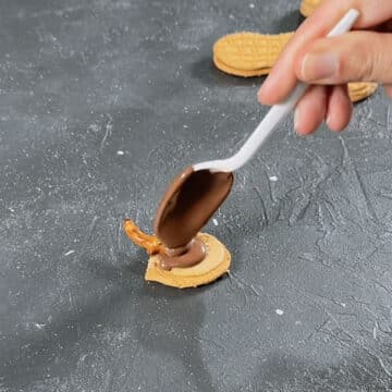 Additional melted chocolate being poured on top of cookie.