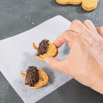 Final cookie being placed on sheet of wax paper. 