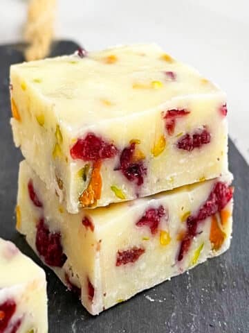 Stack of Easy Sweetened Condensed Milk Fudge With Cranberries, Pistachios on Black Base