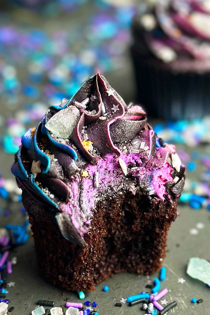 Partially Eaten Chocolate Cupcake With Frosting Swirl on Black Background