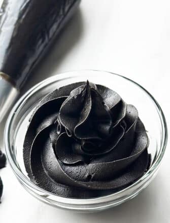 Easy Homemade Black Icing in Glass Bowl on White Background