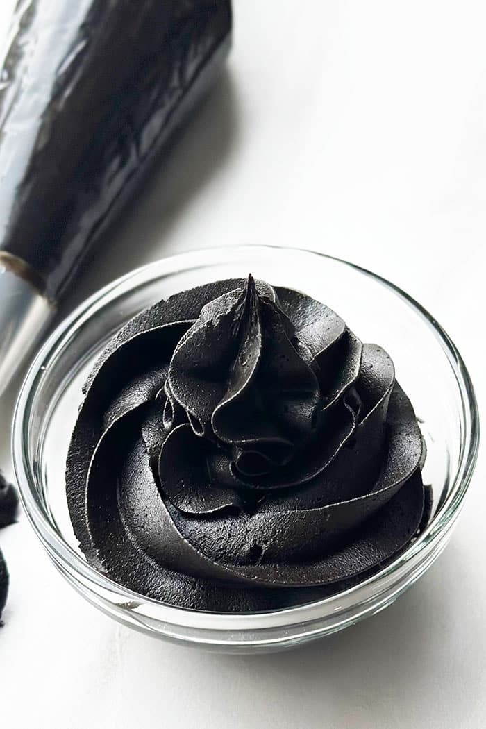 Easy Homemade Black Icing in Glass Bowl on White Background