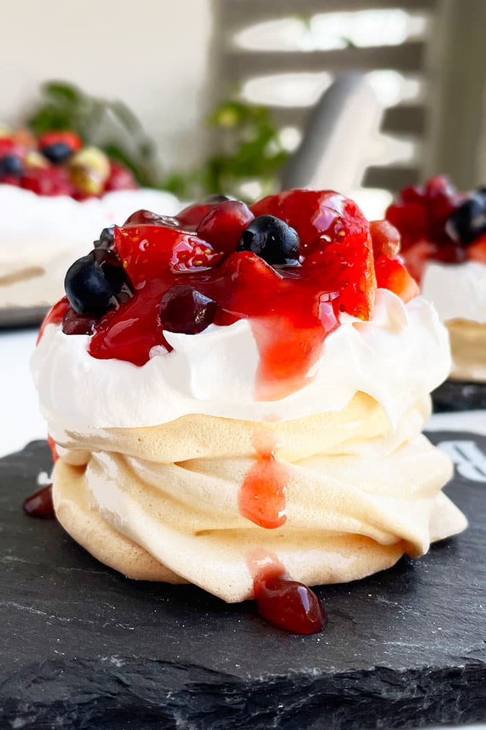 Easy Mini Pavlova Cake With Whipped Cream and Fresh Berries on Black Dish