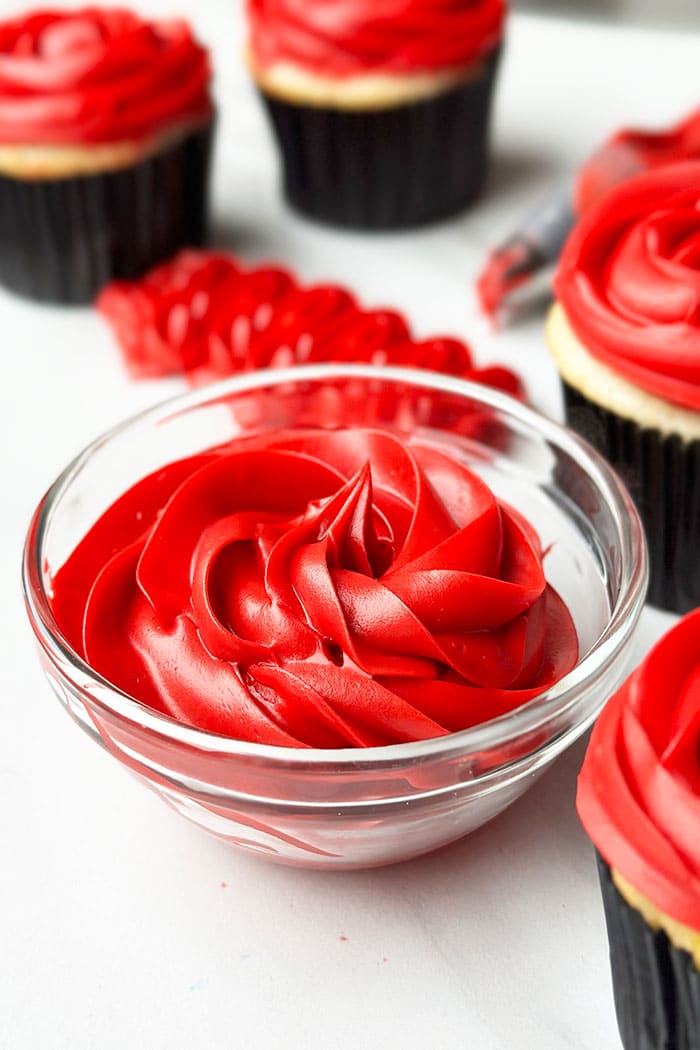 Easy Red Frosting That is Not Pink in Glass Bowl on White Background