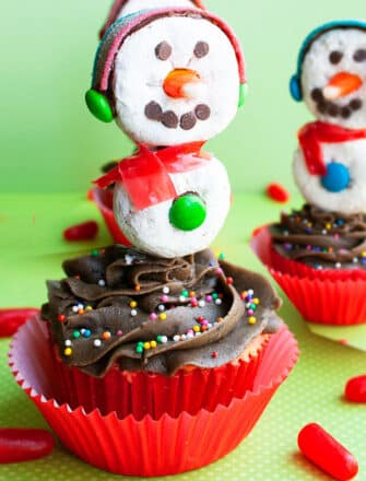 Easy Snowman Cupcakes With Donut Toppers on Green Background