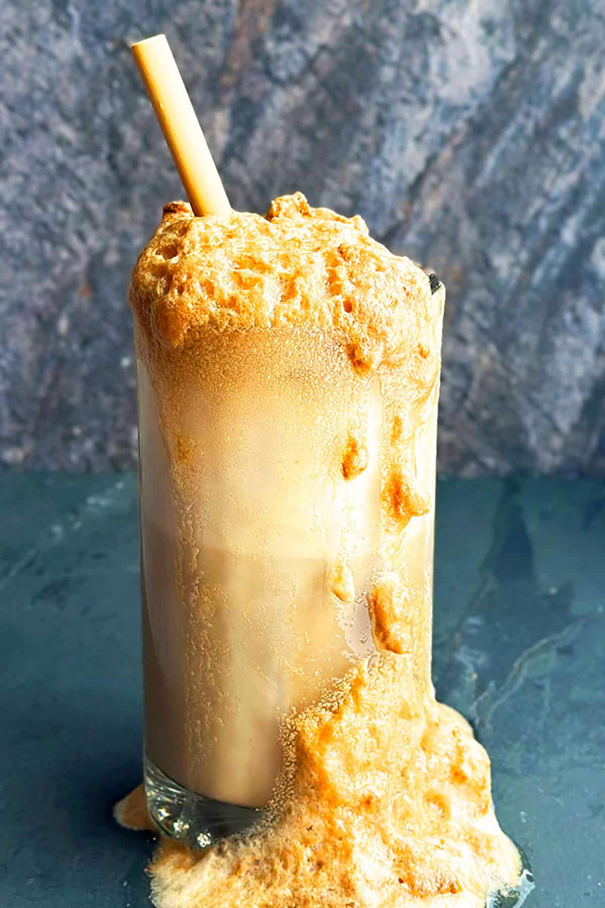 Homemade Root Beer Ice Cream Soda With Foams and Bubbles Flowing Out of Big Glass Mug  
