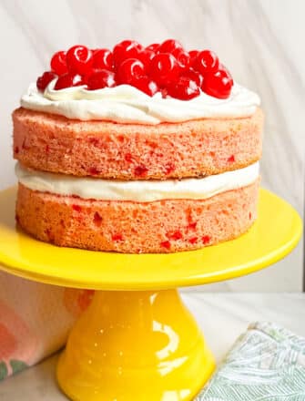 Easy Cherry Cake With Cake Mix and Maraschino Cherries on Yellow Cake Stand With Marble Background