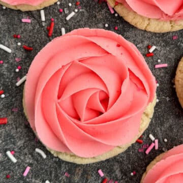 Best Easy Rose Cookies With Pink Buttercream Frosting- Closeup Shot on Rustic Gray Background.