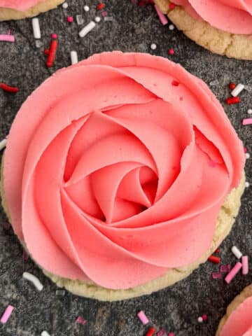Best Easy Rose Cookies With Pink Buttercream Frosting- Closeup Shot on Rustic Gray Background.