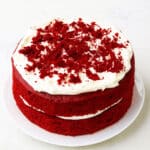 Best easy soft and moist red velvet cake (layer cake) with cream cheese frosting on white dish and white background.
