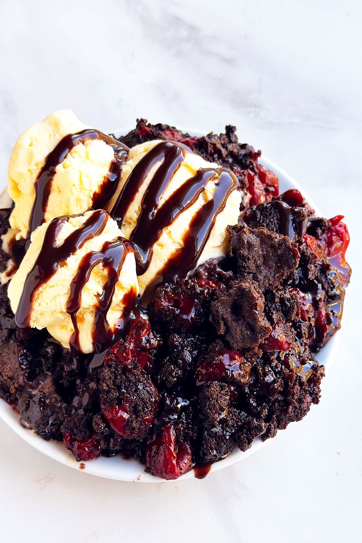 Easy Chocolate Cherry Dump Cake With Cake Mix Topped With Ice Cream on White Dish 